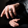 Silver skull ring encrusted with black zirconia on male model.